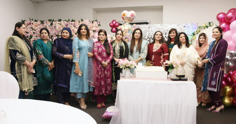 A group of women standing in front of a cake

AI-generated content may be incorrect.