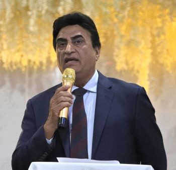 A person in a suit holding a microphone

AI-generated content may be incorrect.