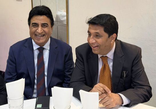 A couple of men in suits sitting at a table

AI-generated content may be incorrect.