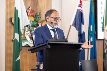 A person standing at a podium with flags behind him

AI-generated content may be incorrect.