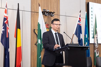 A person standing at a podium with flags behind him

AI-generated content may be incorrect.