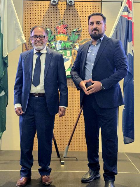 Two men in suits standing in front of flags

AI-generated content may be incorrect.