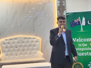 A person in a suit holding a microphone

AI-generated content may be incorrect.