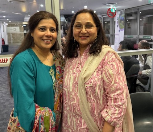 Two women standing together smiling

AI-generated content may be incorrect.