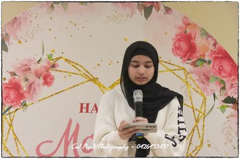 A person in a black head scarf holding a microphone

AI-generated content may be incorrect.