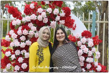 Two women standing in front of a flower arch

AI-generated content may be incorrect.