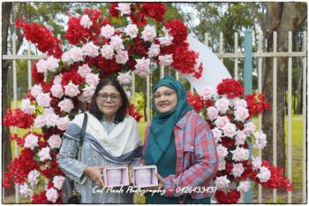 Two women standing in front of a flower arch

AI-generated content may be incorrect.