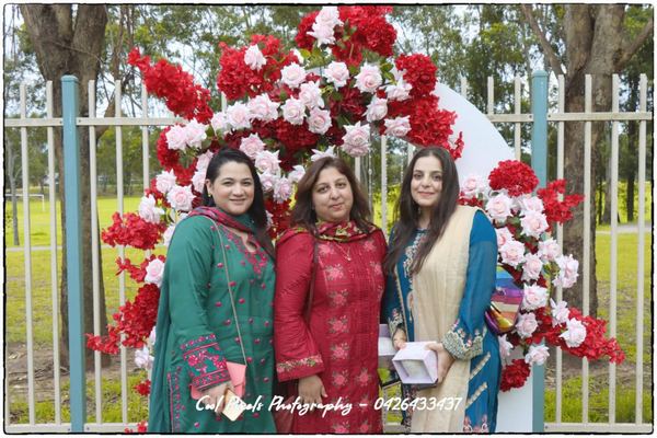 A group of women standing in front of a flower arch

AI-generated content may be incorrect.