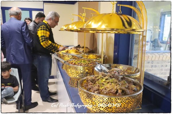 A group of people standing in front of a buffet

AI-generated content may be incorrect.
