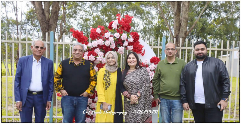 A group of people standing in front of a flower arch

AI-generated content may be incorrect.