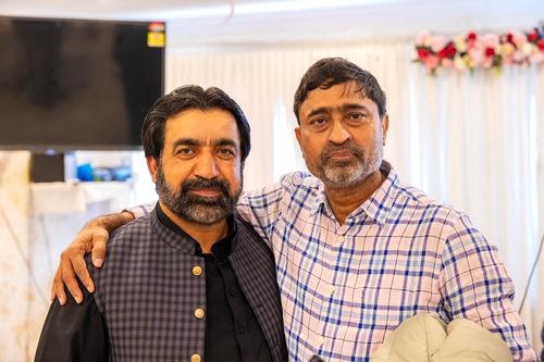 Two men posing for a picture

AI-generated content may be incorrect.