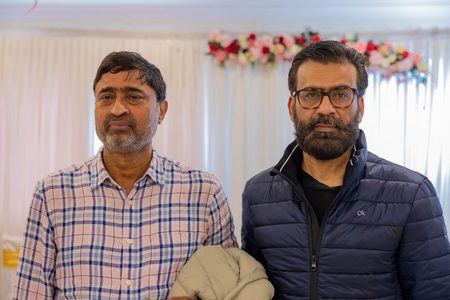 Two men standing next to each other

AI-generated content may be incorrect.