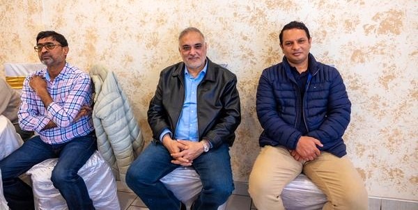 A group of men sitting in a row

AI-generated content may be incorrect.