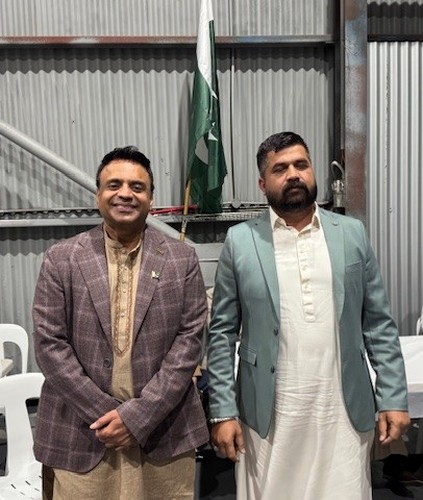 Two men standing in front of a flag

AI-generated content may be incorrect.