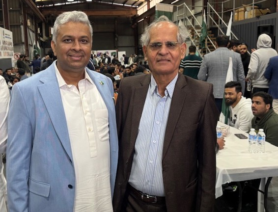 Two men standing together in a room with a crowd of people

AI-generated content may be incorrect.