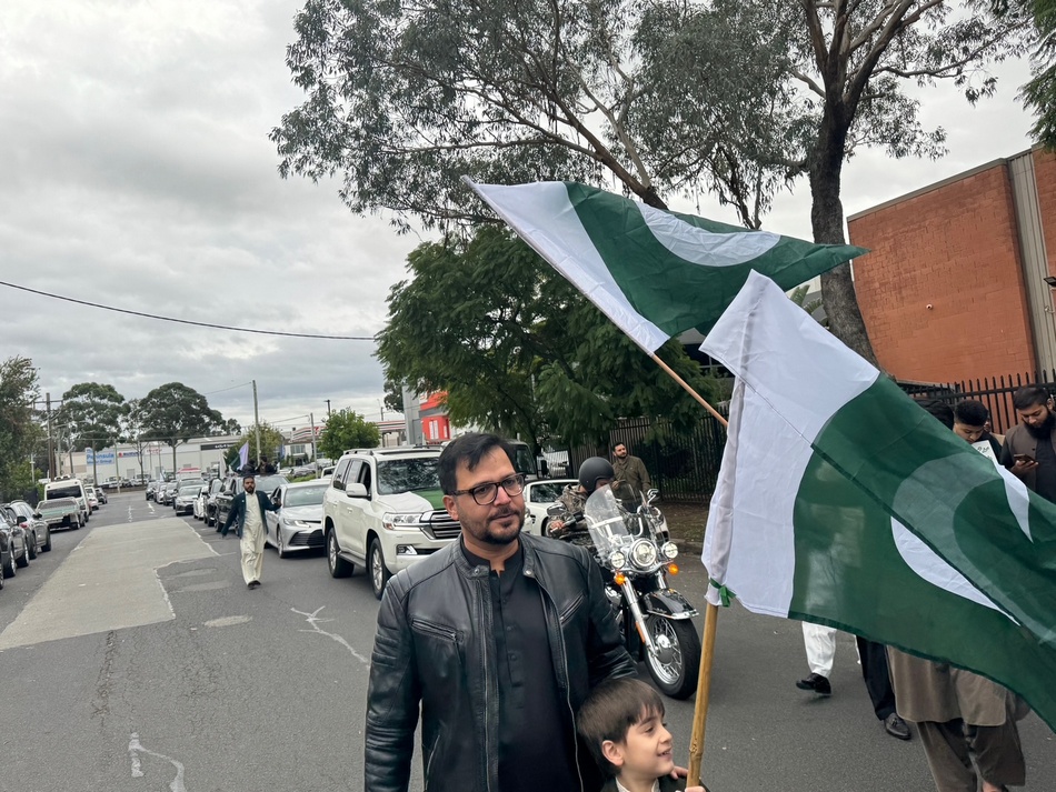 A person and child holding flags on a street

AI-generated content may be incorrect.