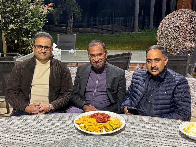 A group of men sitting at a table with a plate of food

AI-generated content may be incorrect.